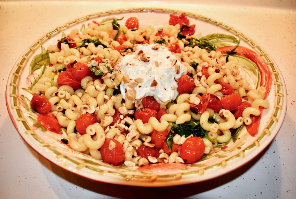 Pasta with citrus scented ricotta, charred pearl tomatoes, wilted baby kale and toasted hazelnuts