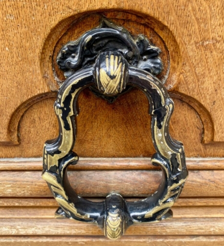 Black and Gold Parisian Door Knocker on a Wood Door