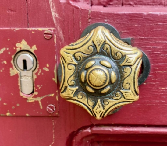 Six-Sided Ornate Parisian Door Knob on a Red Door