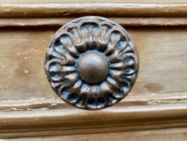 Worn Round Parisian Door Knob on a Tan Door