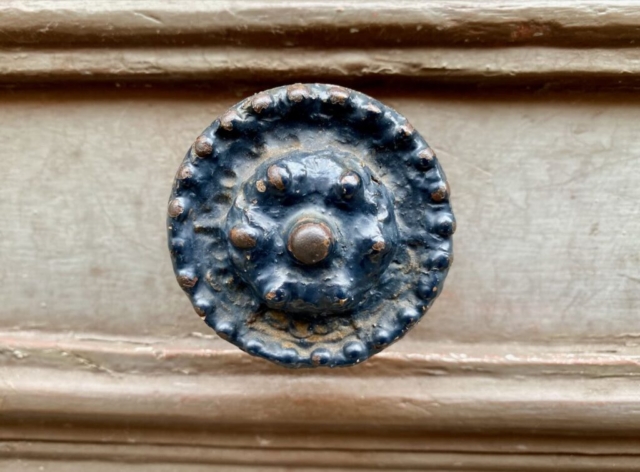 Rusty Round Parisian Door Knob on a Tan Door